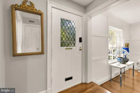 a view of a hallway that has a dresser and a window in it