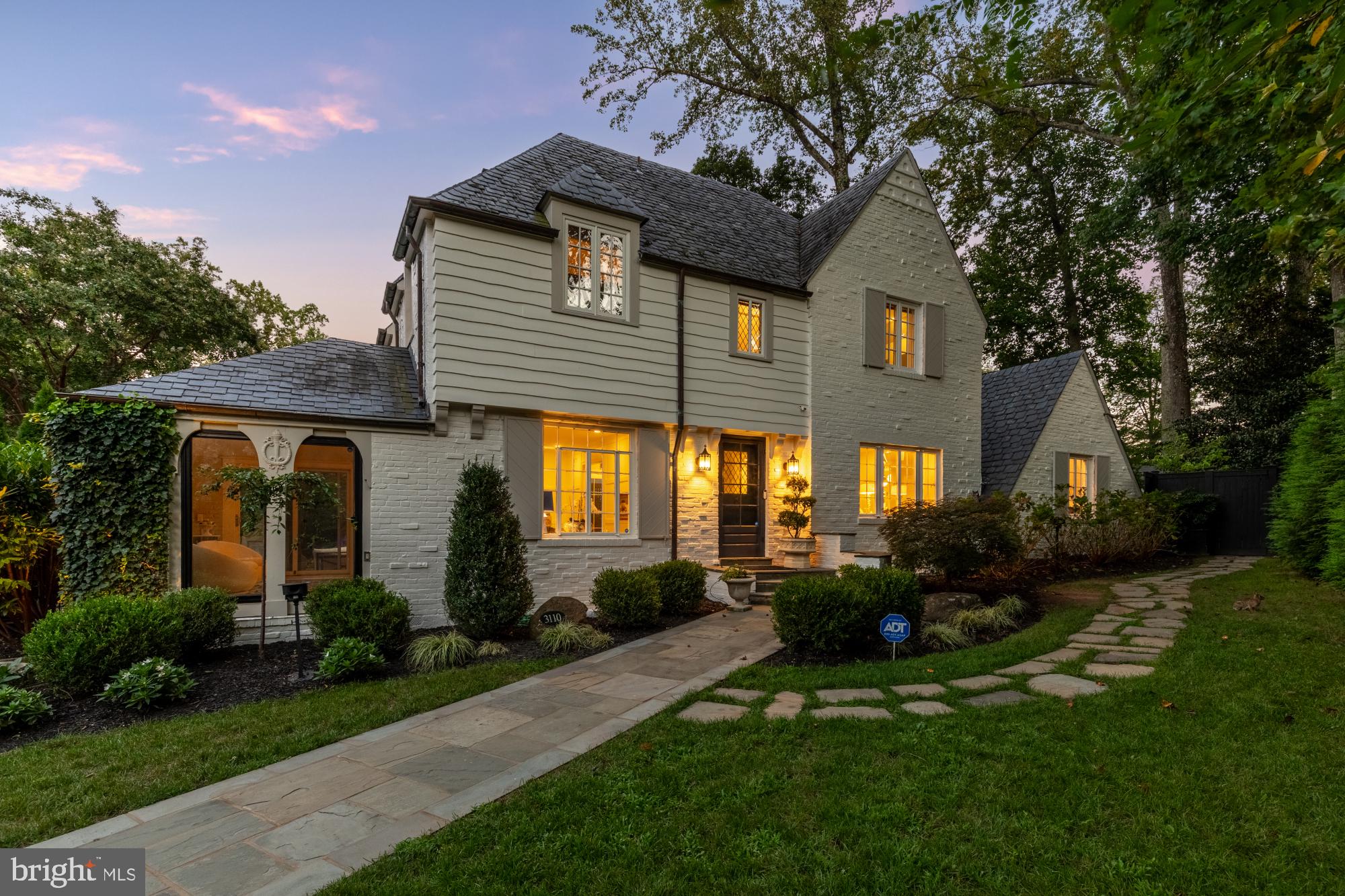 3110 Rolling Road Chevy Chase, MD 20815 - Photo 60 of 64 a front view of a house with a yard and potted plants
