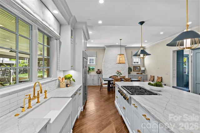a large kitchen with stainless steel appliances a stove a center island and a large window
