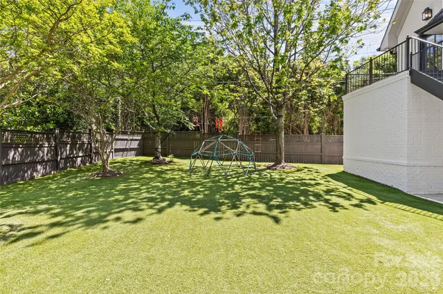 a view of a house with a big yard and large tree