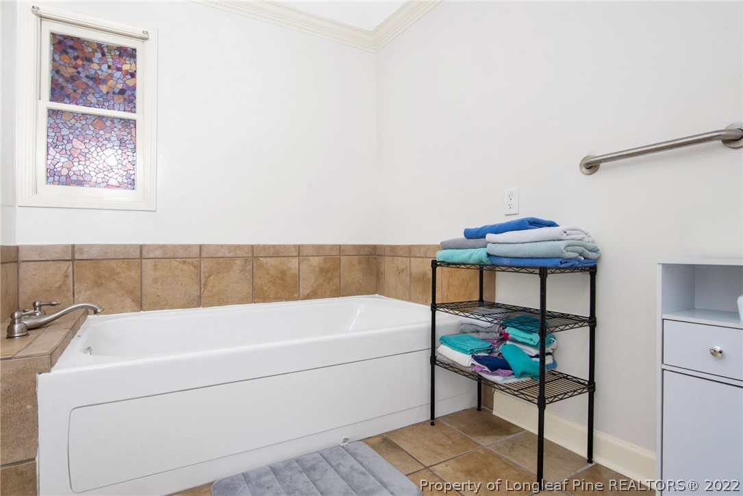 1813 Ashton Road Fayetteville, NC 28304 - Photo 12 of 25 a bathroom with a bathtub and a table