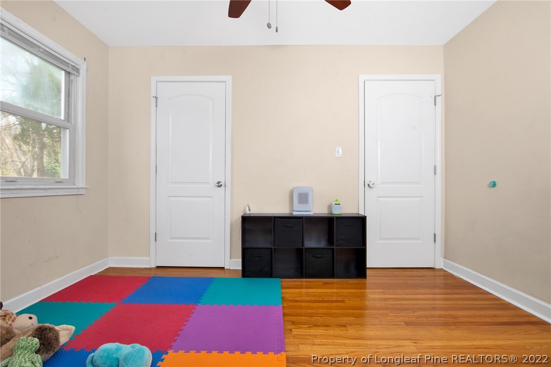 1813 Ashton Road Fayetteville, NC 28304 - Photo 15 of 25 a living room with a bed and a table with wooden floor