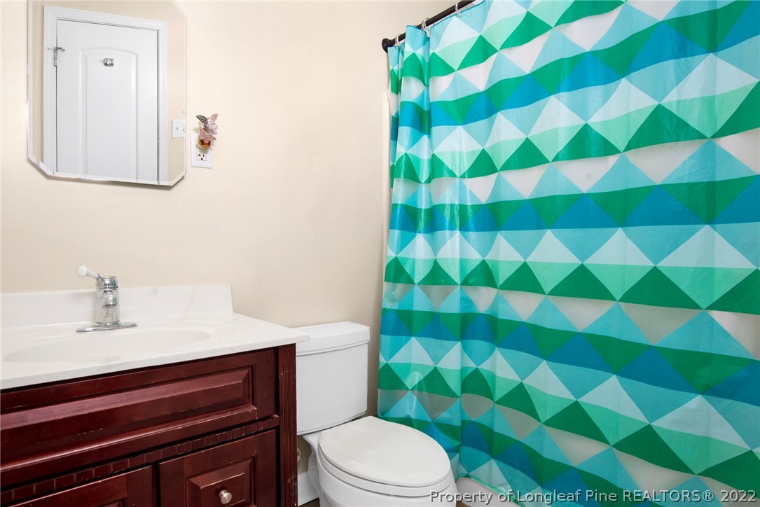 1813 Ashton Road Fayetteville, NC 28304 - Photo 16 of 25 a bathroom with a sink and mirror with toilet