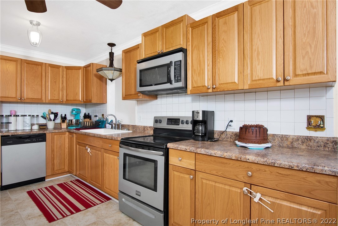 1813 Ashton Road Fayetteville, NC 28304 - Photo 7 of 25 a kitchen with stainless steel appliances granite countertop a sink stove and microwave