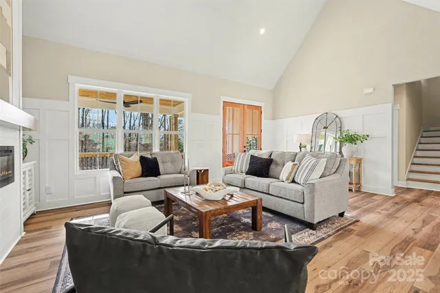 a living room with furniture wooden floor and white walls