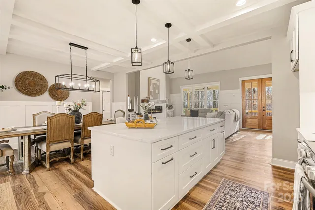a large white kitchen with lots of counter space a sink and appliances