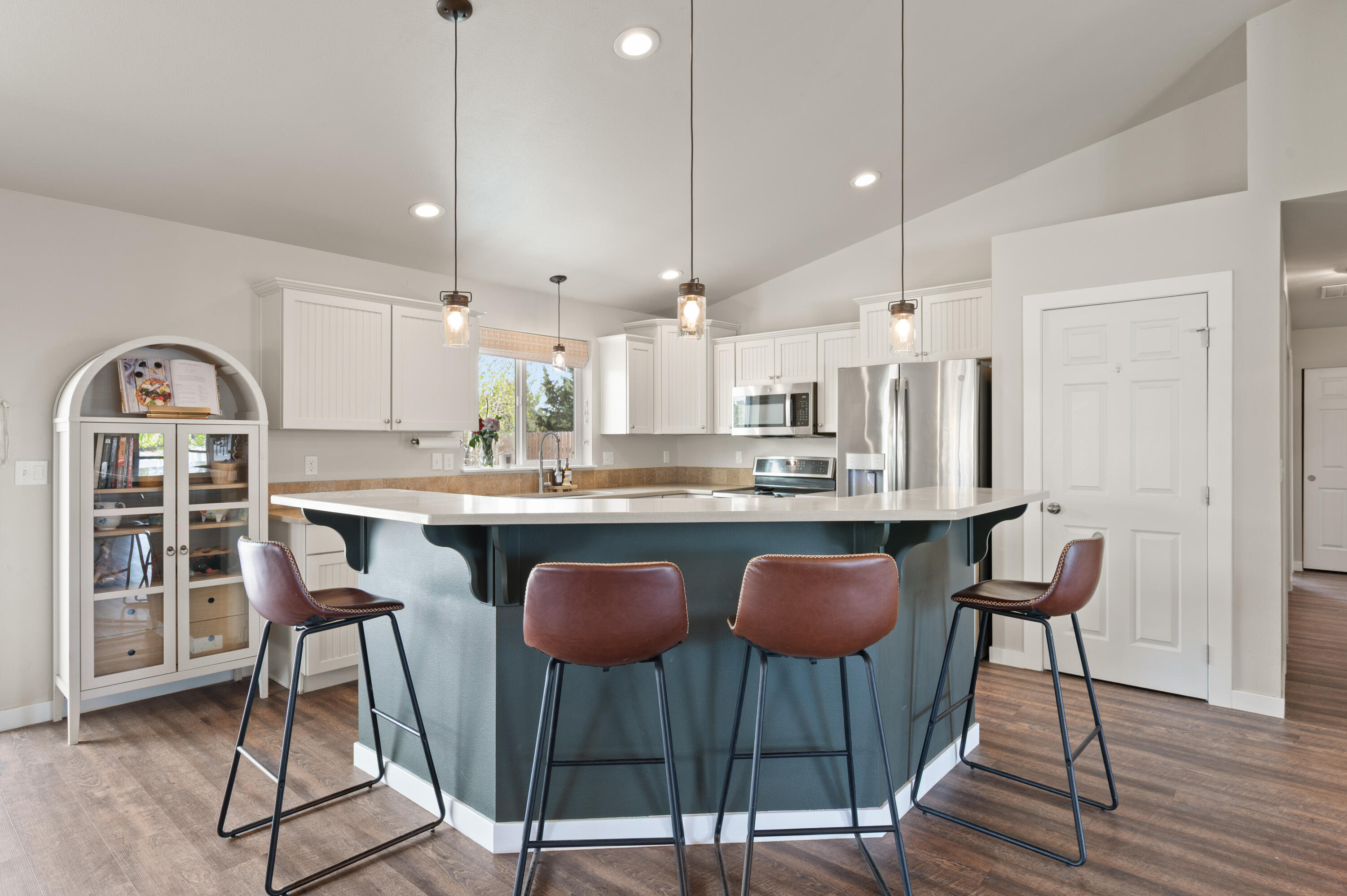 16625 Southwest Dove Road Terrebonne, OR 97760 - Photo 12 of 50 a kitchen with stainless steel appliances granite countertop a stove a sink dishwasher a dining table and chairs with wooden floor