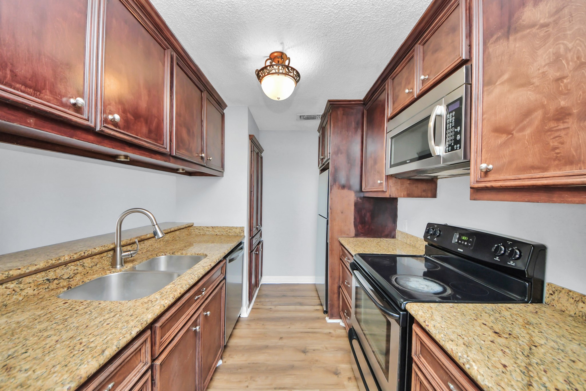 6601 Sands Point Drive, Unit 30 Houston, TX 77074 - Photo 8 of 29 a kitchen with stainless steel appliances granite countertop a stove a sink and a microwave