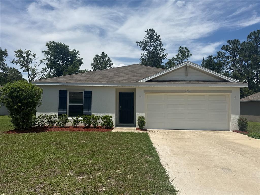 492 Hickory Course Loop Ocala, FL 34472 - Photo 1 of 28 a front view of a house with a garden and yard