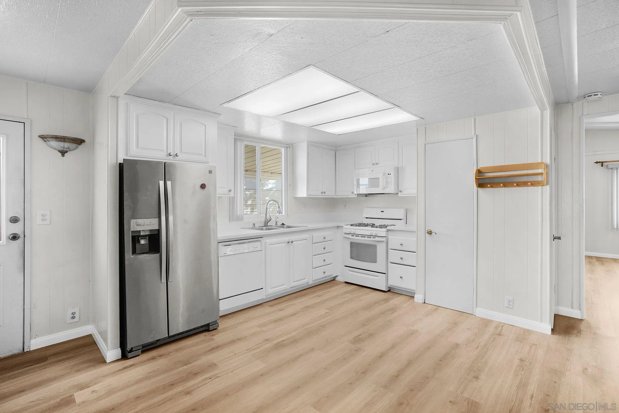 1925 Otay Lakes Road, Unit 167 Chula Vista, CA 91913 - Photo 2 of 11 a kitchen with white cabinets and stainless steel appliances