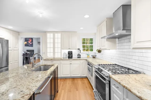 a kitchen with stainless steel appliances granite countertop a sink stove and refrigerator