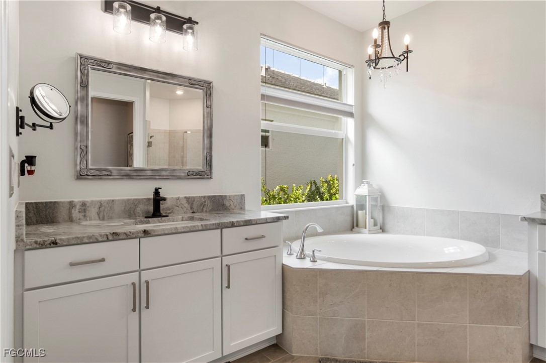 43276 Boardwalk Loop Punta Gorda, FL 33982 - Photo 21 of 50 a bathroom with a granite countertop sink and a mirror