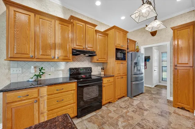 a kitchen with stainless steel appliances granite countertop a refrigerator a stove and a sink with cabinets