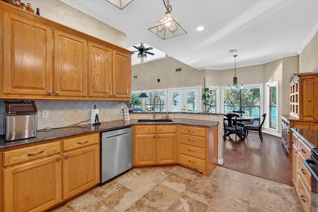 a kitchen with stainless steel appliances granite countertop a stove refrigerator sink and cabinets