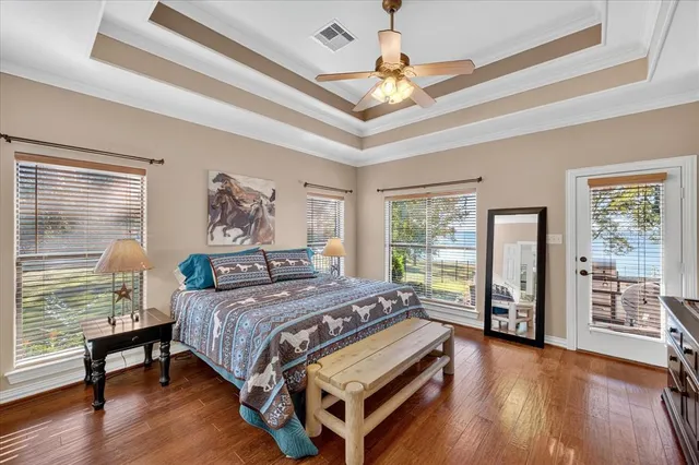 a bedroom with a large bed a chandelier and windows