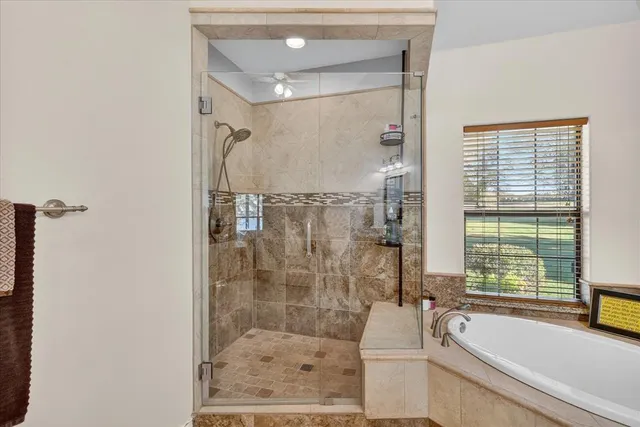 a bathroom with a granite countertop bathtub shower and vanity