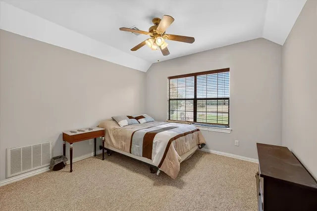 a bed sitting in a bedroom next to a window