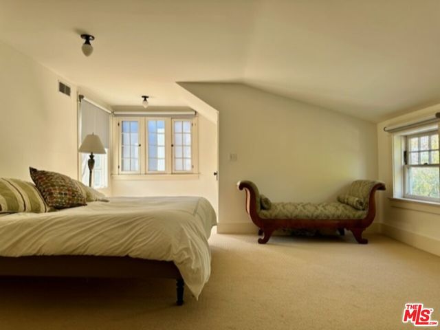 a bedroom with a bed and windows