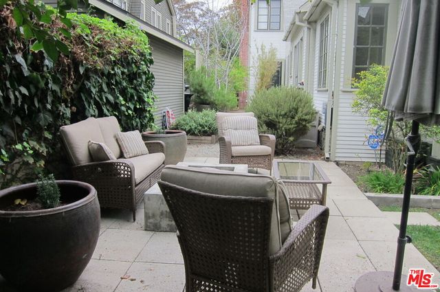 a view of backyard with outdoor seating and plants