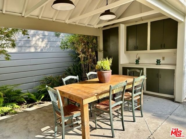 a patio with table and chairs and potted plants