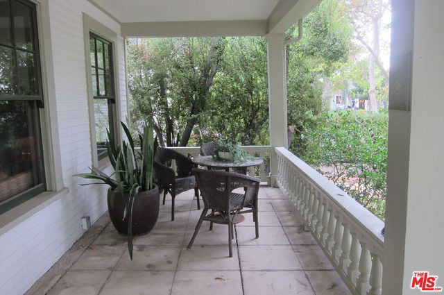 a view of a balcony with furniture and a potted plant