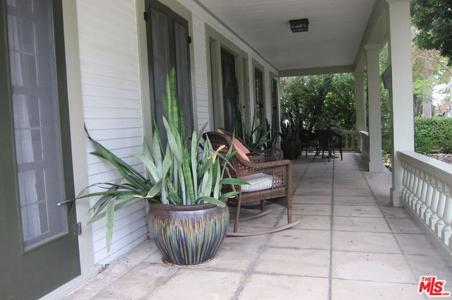 a view of a porch with chairs and potted plants