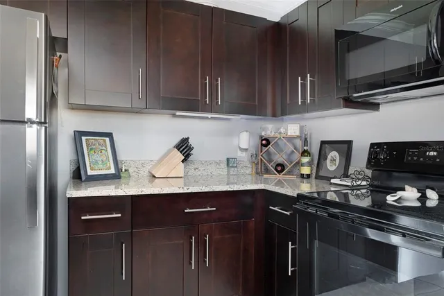 a kitchen with stainless steel appliances granite countertop a sink a stove and cabinets