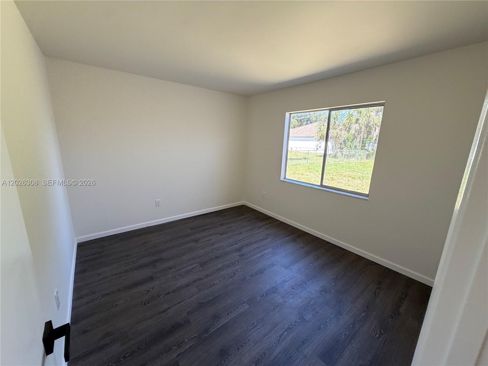 653 Atlas Avenue Northeast Palm Bay, FL 32905 - Photo 13 of 22 an empty room with wooden floor and windows