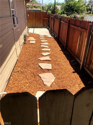 a view of a backyard with wooden fence