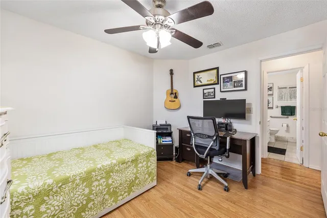 a view of a bedroom with workspace and wooden floor