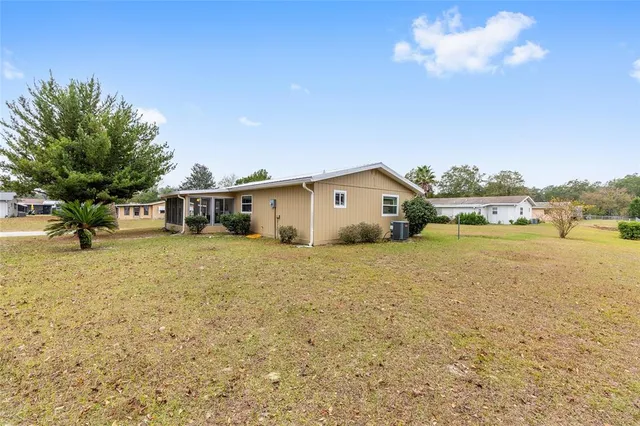 a view of a house with backyard and tree