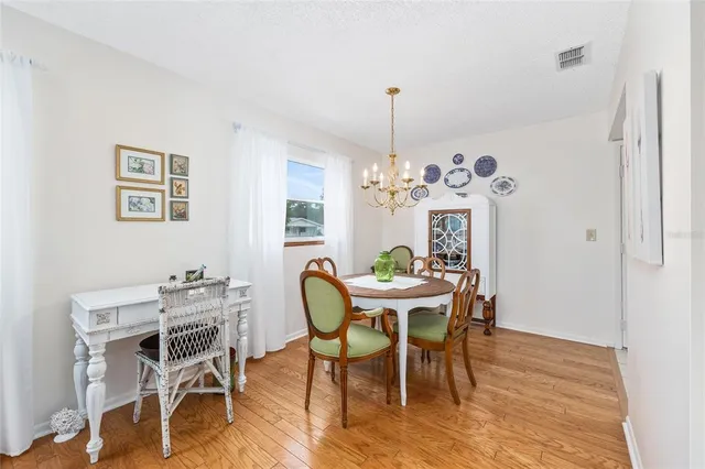 a view of a dining room with furniture a chandelier and wooden floor