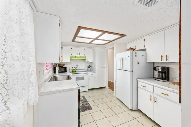 a kitchen with stainless steel appliances a refrigerator sink and cabinets