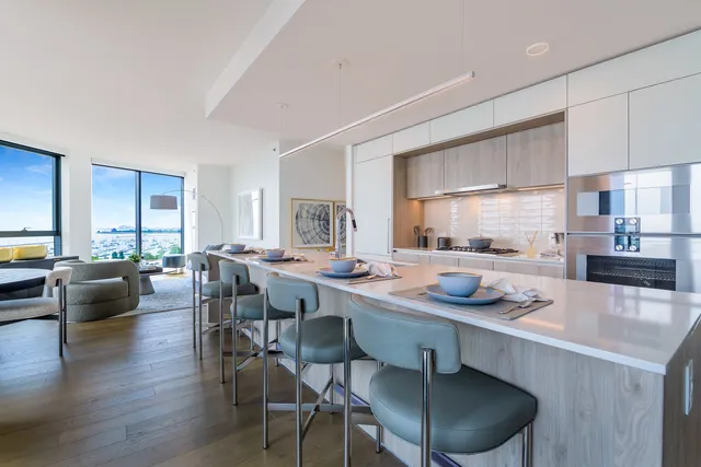 a dining room with furniture a kitchen view and wooden floor