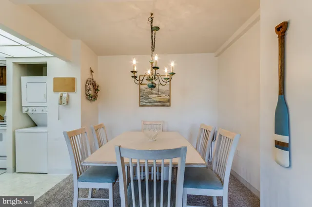 a dining room with wooden floor a chandelier a wooden table and chairs