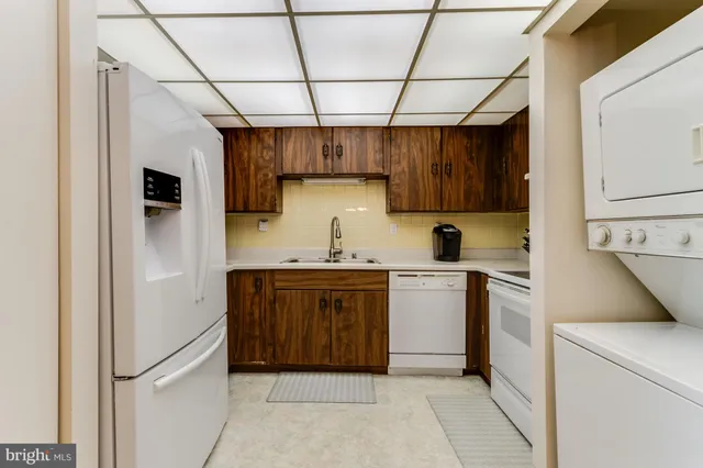a large bed sitting in a bedroom next to a window with lamp on table
