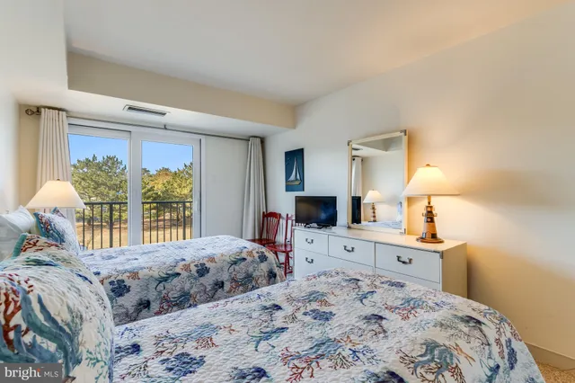 a bedroom with a bed and a lamp on dresser