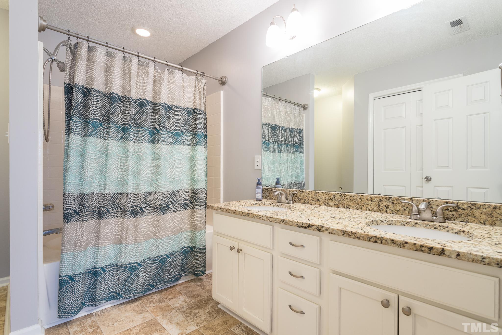 4428 Antique Lane Raleigh, NC 27616 - Photo 24 of 30 a bathroom with a granite countertop sink a mirror and shower