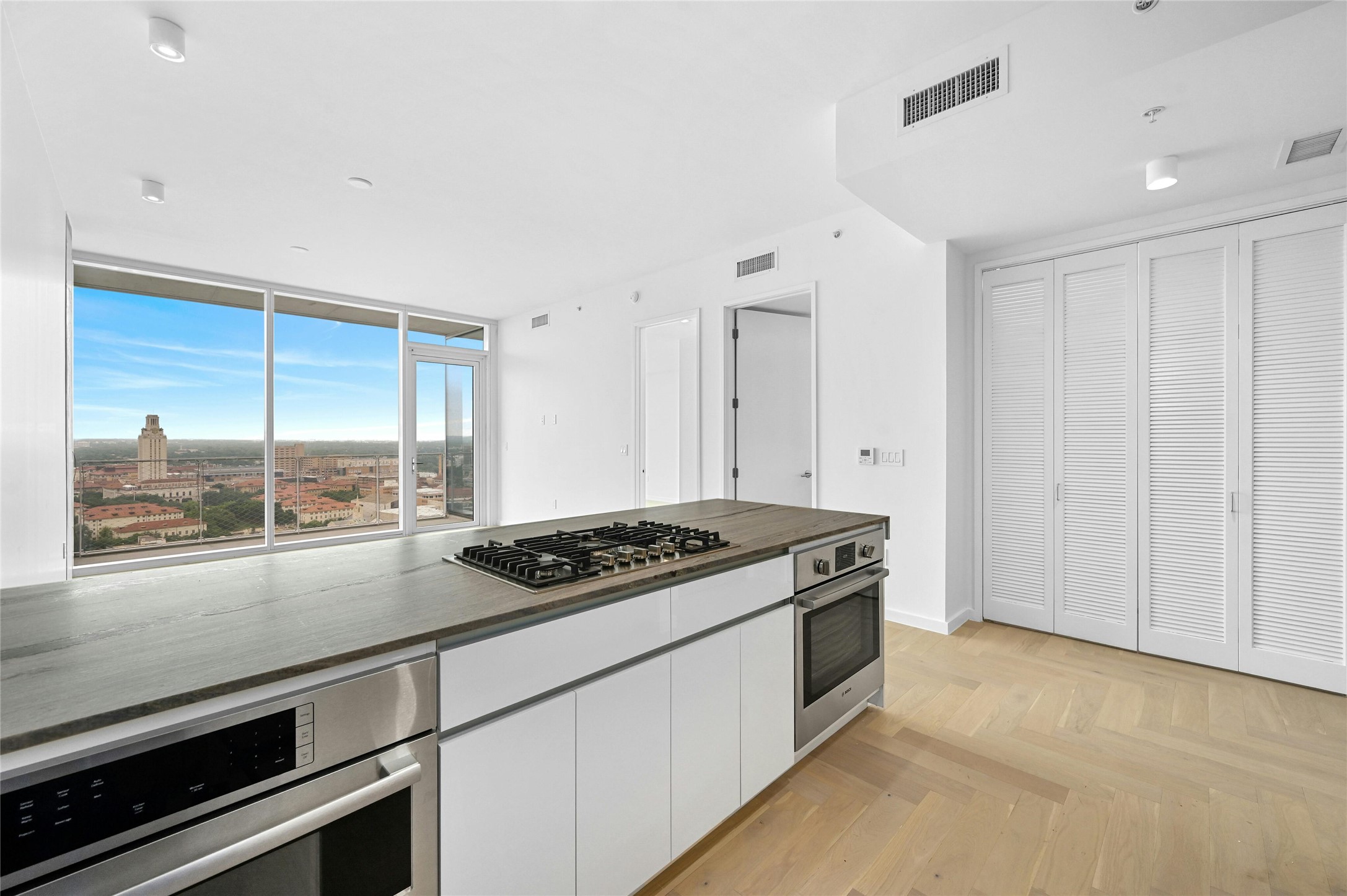 313 West 17th Street, Unit 1702 Austin, TX 78701 - Photo 2 of 34 Residence 1702 offers an open living design with a chef-inspired kitchen featuring Bosch® appliances, gas cooktop, and a stone waterfall island. Floor-to-ceiling windows open to a private balcony and capture stunning views of the UT Tower and Austin skyline.