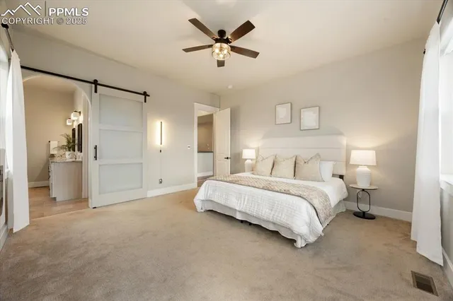 a spacious bedroom with a bed and a ceiling fan