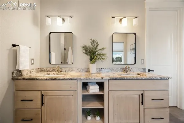 a bathroom with a granite countertop sink and a mirror