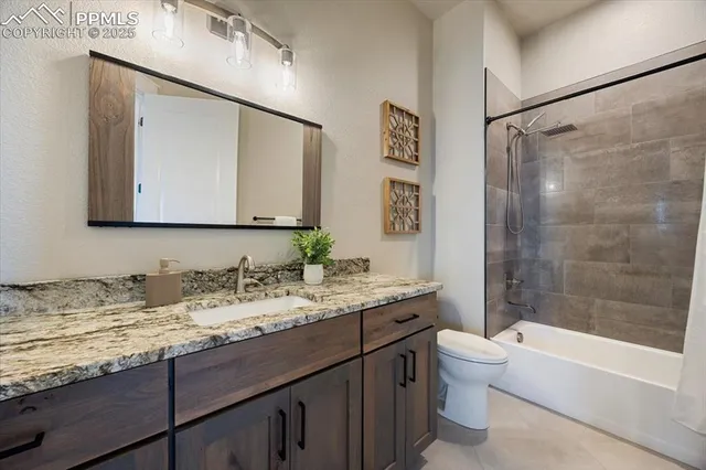 a bathroom with a granite countertop sink toilet mirror and bathtub