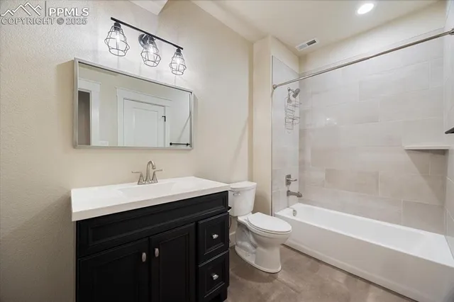 a bathroom with a toilet a sink a mirror a bathtub and vanity