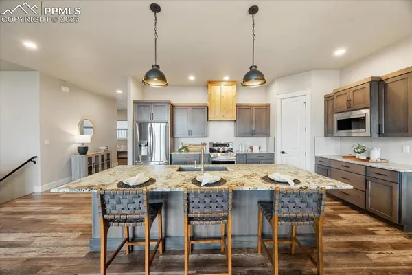 a kitchen with granite countertop a dining table chairs and wooden floor