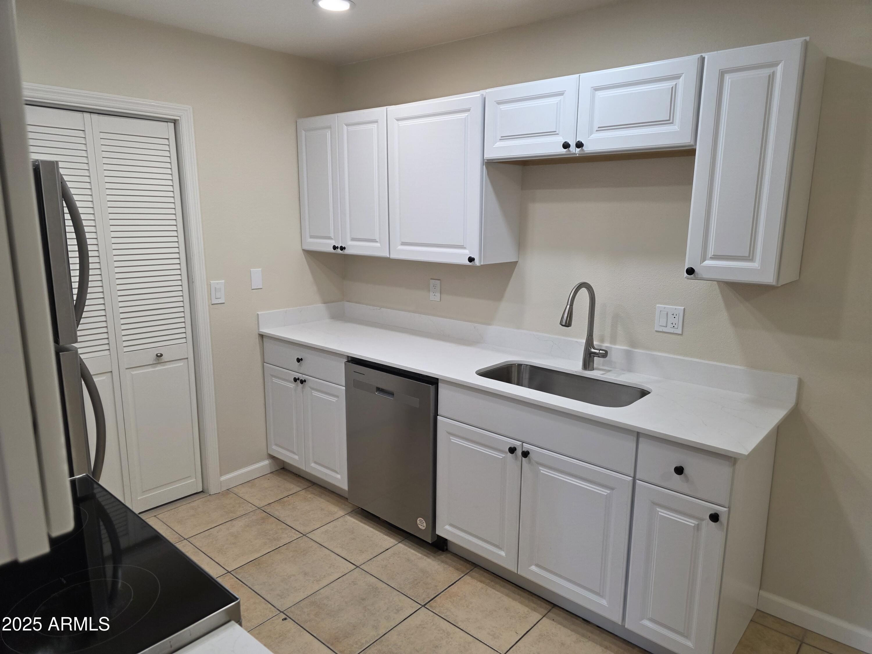 3511 East Baseline Road, Unit 1117 Phoenix, AZ 85042 - Photo 4 of 30 a kitchen with white cabinets and a sink