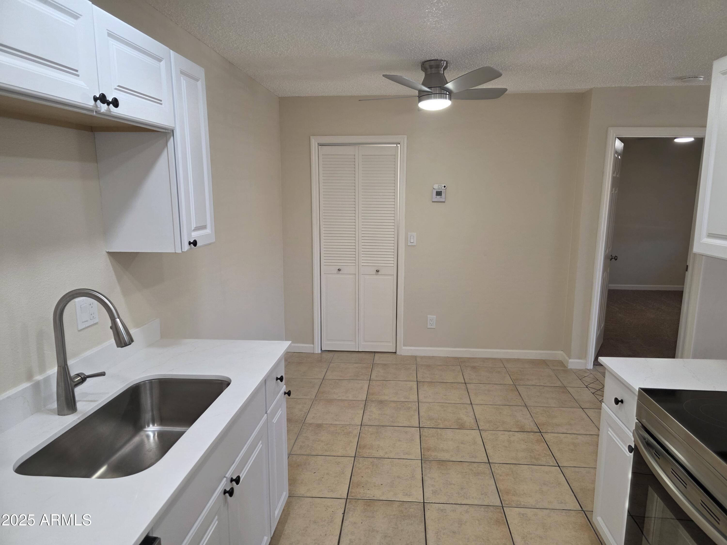 3511 East Baseline Road, Unit 1117 Phoenix, AZ 85042 - Photo 5 of 30 a kitchen with a sink a stove and cabinets