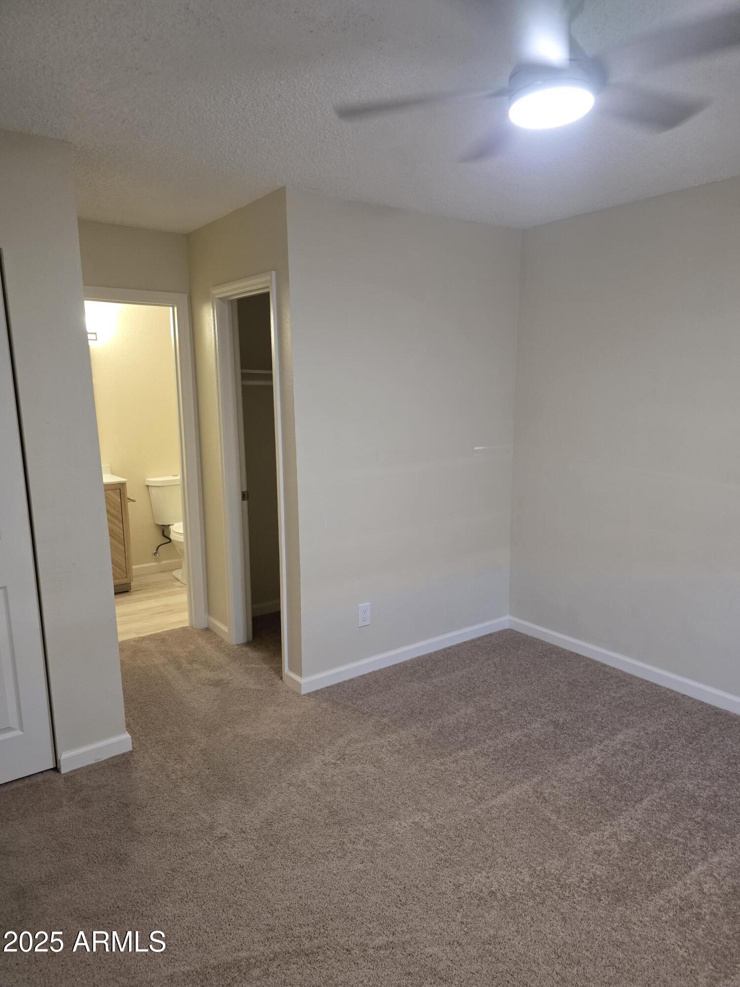 3511 East Baseline Road, Unit 1117 Phoenix, AZ 85042 - Photo 10 of 30 an empty room with closet and a chandelier fan