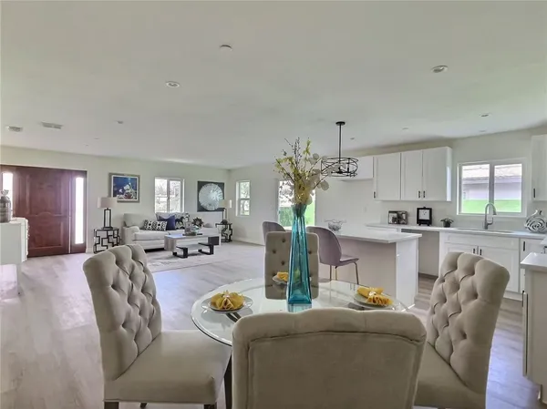 a living room with furniture and a dining table with kitchen view