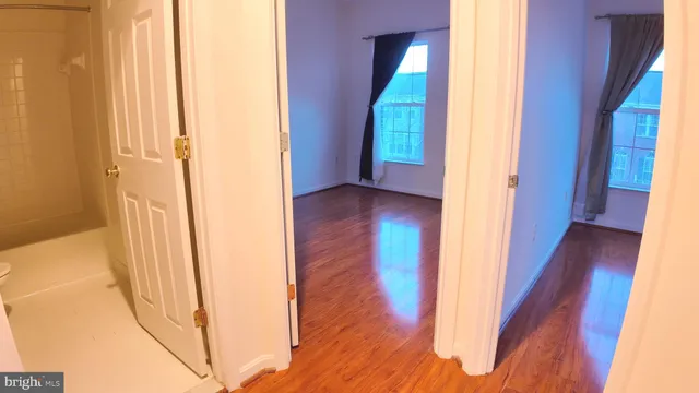 a view of a hallway with wooden floor