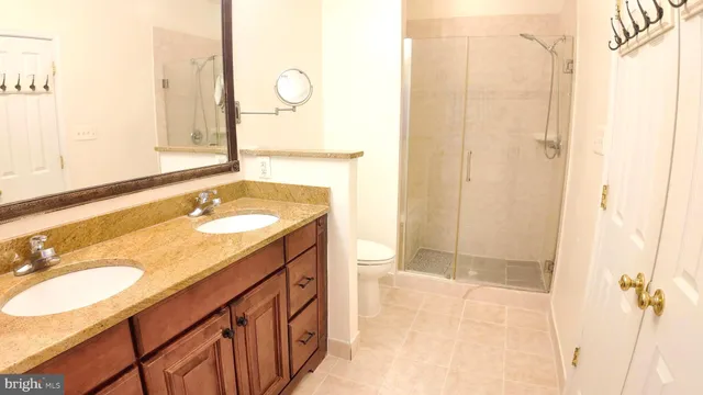 a bathroom with a granite countertop sink a mirror and a shower